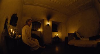 Movie still from “The Favourite” (2018), directed by Yorgos Lanthimos – A woman sitting on a chair in a dimly - lit room; Wide shot, Overhead angle