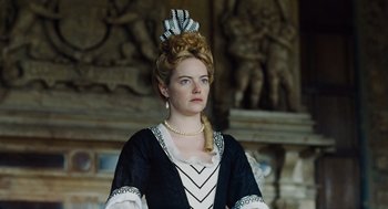 Movie still from “The Favourite” (2018), directed by Yorgos Lanthimos – A woman in a black and white dress with a feather in her hair; Close Up shot, Low angle