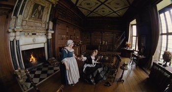 Movie still from “The Favourite” (2018), directed by Yorgos Lanthimos – Two women dressed in period clothing in a room; Wide shot, High angle