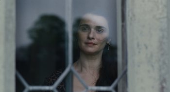 Movie still from “The Favourite” (2018), directed by Yorgos Lanthimos – A woman looking out of a window through a window; Close Up shot, Over the shoulder angle