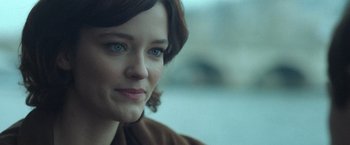 A woman's face in a brown jacket