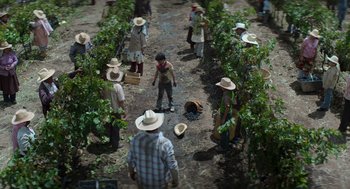 Movie still from “A Million Miles Away” (2023), directed by Alejandra Márquez Abella – A group of people standing in a field with hats on; Wide shot, High angle