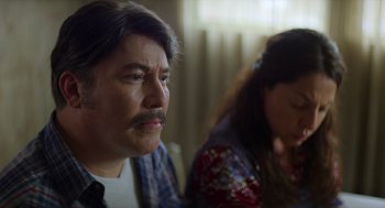 Movie still from “A Million Miles Away” (2023), directed by Alejandra Márquez Abella – A man and a woman sitting next to each other in a room; Close Up shot, Over the shoulder angle
