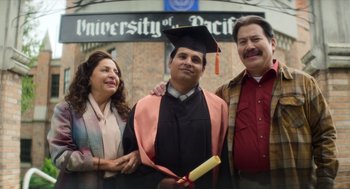 Movie still from “A Million Miles Away” (2023), directed by Alejandra Márquez Abella – Three people standing in front of a university of pacific sign; Medium shot, High angle