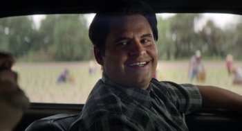 Movie still from “A Million Miles Away” (2023), directed by Alejandra Márquez Abella – A man sitting in the back seat of a car; Close Up shot, Over the shoulder angle