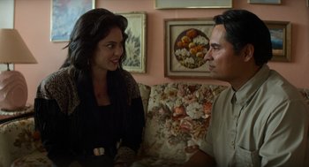 Movie still from “A Million Miles Away” (2023), directed by Alejandra Márquez Abella – A man and a woman sitting on a couch talking to each other; Medium shot, Over the shoulder angle