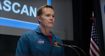Movie still from “A Million Miles Away” (2023), directed by Alejandra Márquez Abella – A man in a blue nasa jacket is speaking; Close Up shot, Low angle