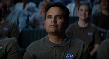 Movie still from “A Million Miles Away” (2023), directed by Alejandra Márquez Abella – A man in a nasa shirt is looking up at the sky; Close Up shot, Low angle