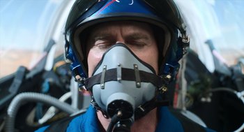Movie still from “A Million Miles Away” (2023), directed by Alejandra Márquez Abella – A man wearing a motorcycle helmet and a gas mask; Close Up shot, Overhead angle