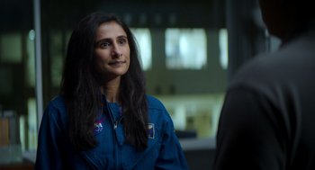 Movie still from “A Million Miles Away” (2023), directed by Alejandra Márquez Abella – A woman in a blue space suit is looking at something; Close Up shot, Over the shoulder angle