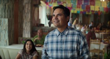 Movie still from “A Million Miles Away” (2023), directed by Alejandra Márquez Abella – A man standing in front of a group of people in a room; Medium shot, Over the shoulder angle