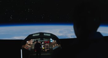 Movie still from “A Million Miles Away” (2023), directed by Alejandra Márquez Abella – A person in the cockpit of an airplane; Extreme Wide shot, Over the shoulder angle