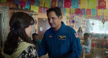 Movie still from “A Million Miles Away” (2023), directed by Alejandra Márquez Abella – A man in a blue space suit talking to a woman; Medium shot, Over the shoulder angle