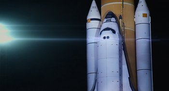 Movie still from “A Million Miles Away” (2023), directed by Alejandra Márquez Abella – A space shuttle on the side of a building; Extreme Wide shot, Low angle
