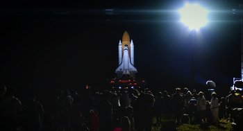 Movie still from “A Million Miles Away” (2023), directed by Alejandra Márquez Abella – A group of people standing in front of a space ship; Extreme Wide shot, Low angle