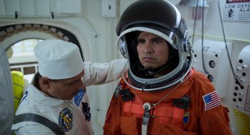 Movie still from “A Million Miles Away” (2023), directed by Alejandra Márquez Abella – A man in a space suit and a man in an astronaut's hat; Medium shot, Over the shoulder angle