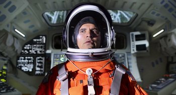 Movie still from “A Million Miles Away” (2023), directed by Alejandra Márquez Abella – A man in an orange space suit and a helmet; Medium shot, Low angle