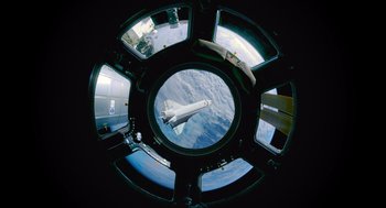 Movie still from “A Million Miles Away” (2023), directed by Alejandra Márquez Abella – A view of a space shuttle from inside a space ship; Extreme Wide shot, Overhead angle