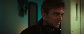 Movie still from “A Night at the Kindergarten” (2022), directed by Rafal Skalski – A person wearing headphones; Close Up shot, Low angle