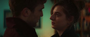 Movie still from “A Night at the Kindergarten” (2022), directed by Rafal Skalski – A man and a woman face to face in front of a green wall; Close Up shot, Over the shoulder angle