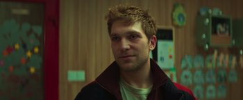 Movie still from “A Night at the Kindergarten” (2022), directed by Rafal Skalski – A young man with spiky red hair is looking at the camera; Close Up shot, Low angle