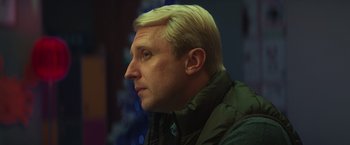 Movie still from “A Night at the Kindergarten” (2022), directed by Rafal Skalski – A person wearing a jacket; Close Up shot, Low angle