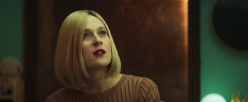 Movie still from “A Night at the Kindergarten” (2022), directed by Rafal Skalski – A woman with blonde hair is looking to her left; Close Up shot, Low angle