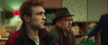 Movie still from “A Night at the Kindergarten” (2022), directed by Rafal Skalski – A man in a hat and a man in a jacket; Close Up shot, Over the shoulder angle