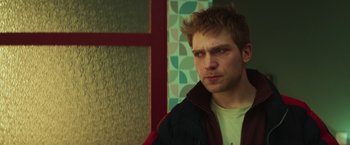 Movie still from “A Night at the Kindergarten” (2022), directed by Rafal Skalski – A man with spiky red hair and a jacket; Close Up shot, Low angle