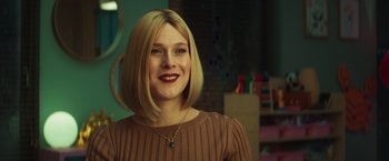 Movie still from “A Night at the Kindergarten” (2022), directed by Rafal Skalski – A woman with blonde hair wearing a brown sweater; Close Up shot, Over the shoulder angle