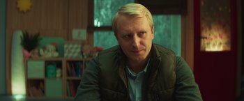 Movie still from “A Night at the Kindergarten” (2022), directed by Rafal Skalski – A person wearing a jacket; Close Up shot, Over the shoulder angle