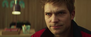 Movie still from “A Night at the Kindergarten” (2022), directed by Rafal Skalski – A man's face in a red shirt; Close Up shot, Low angle