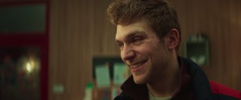 Movie still from “A Night at the Kindergarten” (2022), directed by Rafal Skalski – A person smiling; Close Up shot, Low angle