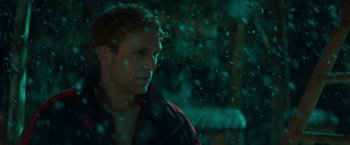 Movie still from “A Night at the Kindergarten” (2022), directed by Rafal Skalski – A man standing in front of a snow covered wall; Close Up shot, Low angle