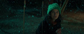 Movie still from “A Night at the Kindergarten” (2022), directed by Rafal Skalski – A woman in a green hat is standing in the snow; Close Up shot, Over the shoulder angle