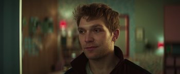 Movie still from “A Night at the Kindergarten” (2022), directed by Rafal Skalski – A person wearing a brown jacket; Close Up shot, Low angle
