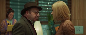 Movie still from “A Night at the Kindergarten” (2022), directed by Rafal Skalski – A man and a woman face to face in front of a window; Close Up shot, Over the shoulder angle