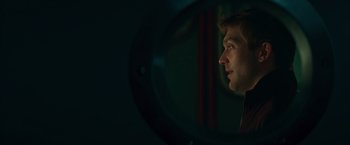 Movie still from “A Night at the Kindergarten” (2022), directed by Rafal Skalski – A man looking into a mirror in a dark room; Close Up shot, Over the shoulder angle