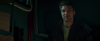 Movie still from “A Night at the Kindergarten” (2022), directed by Rafal Skalski – A man in a dark room looking at the camera; Close Up shot, Low angle