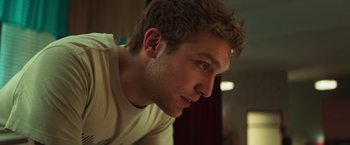 Movie still from “A Night at the Kindergarten” (2022), directed by Rafal Skalski – A young man's face; Close Up shot, Low angle