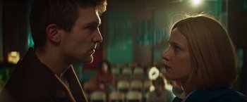 Movie still from “A Night at the Kindergarten” (2022), directed by Rafal Skalski – A man and a woman face to face in a room; Close Up shot, Low angle