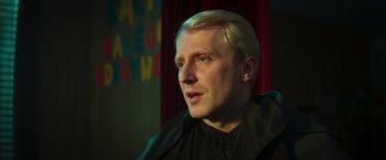Movie still from “A Night at the Kindergarten” (2022), directed by Rafal Skalski – A person with blond hair; Close Up shot, Low angle