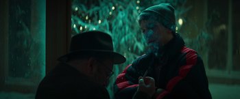 Movie still from “A Night at the Kindergarten” (2022), directed by Rafal Skalski – A man smoking a cigarette next to another man in a hat; Close Up shot, Over the shoulder angle