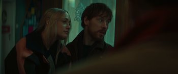 Movie still from “A Night at the Kindergarten” (2022), directed by Rafal Skalski – A man and a woman looking out of a window; Close Up shot, Over the shoulder angle