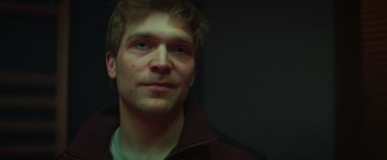 Movie still from “A Night at the Kindergarten” (2022), directed by Rafal Skalski – A person wearing a jacket; Close Up shot, Low angle