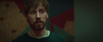 Movie still from “A Night at the Kindergarten” (2022), directed by Rafal Skalski – A person wearing a green shirt; Close Up shot, Over the shoulder angle