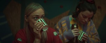 Movie still from “A Night at the Kindergarten” (2022), directed by Rafal Skalski – A woman is drinking a cup of coffee; Close Up shot, Over the shoulder angle