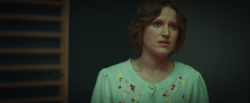 Movie still from “A Night at the Kindergarten” (2022), directed by Rafal Skalski – A person wearing a sweater; Close Up shot, Low angle