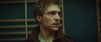 Movie still from “A Night at the Kindergarten” (2022), directed by Rafal Skalski – A person wearing a jacket; Close Up shot, Low angle