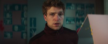 Movie still from “A Night at the Kindergarten” (2022), directed by Rafal Skalski – A person wearing a jacket; Close Up shot, Low angle